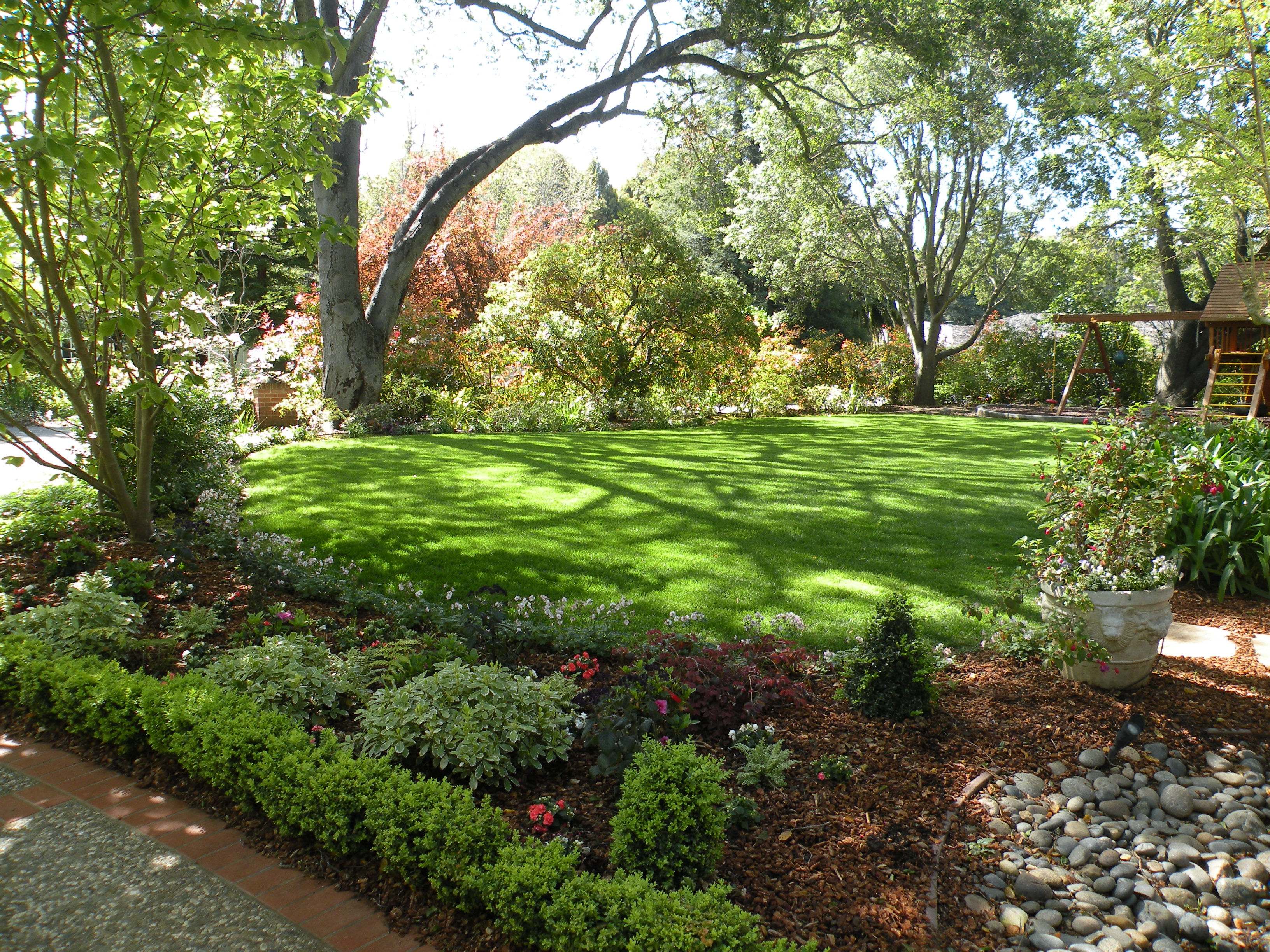 A tended lawn framed by deep mixed borders